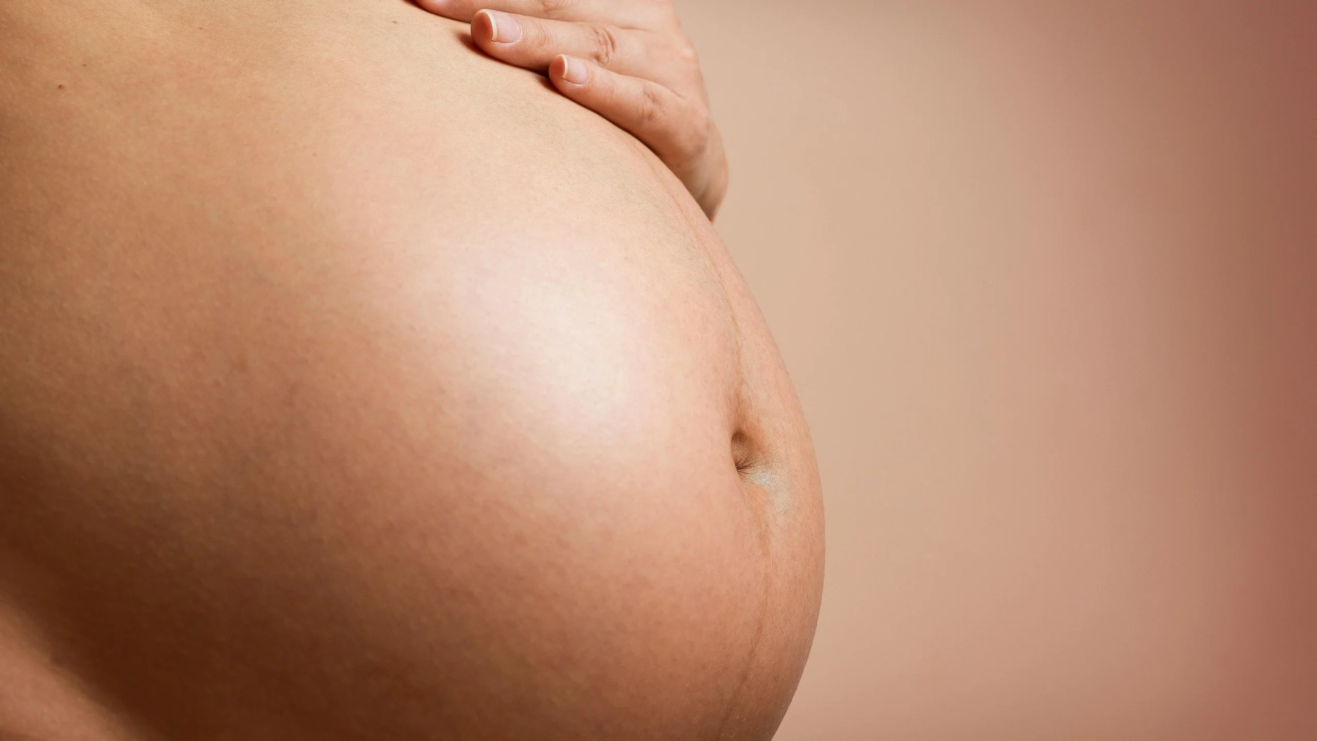 Hand on a bloated abdomen during perimenopause