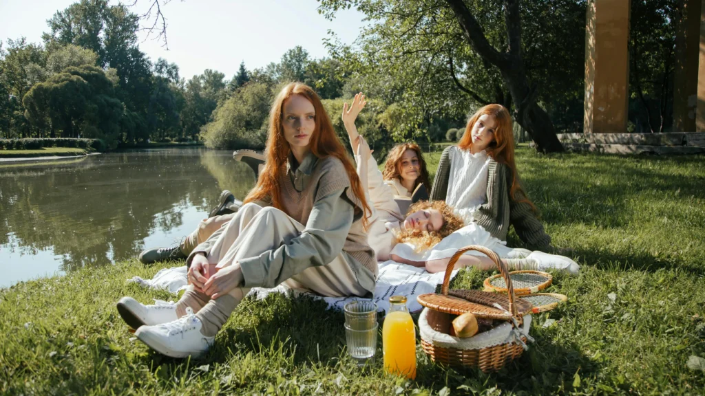 Women enjoying a riverbank picnic, discussing boob heat rash solutions