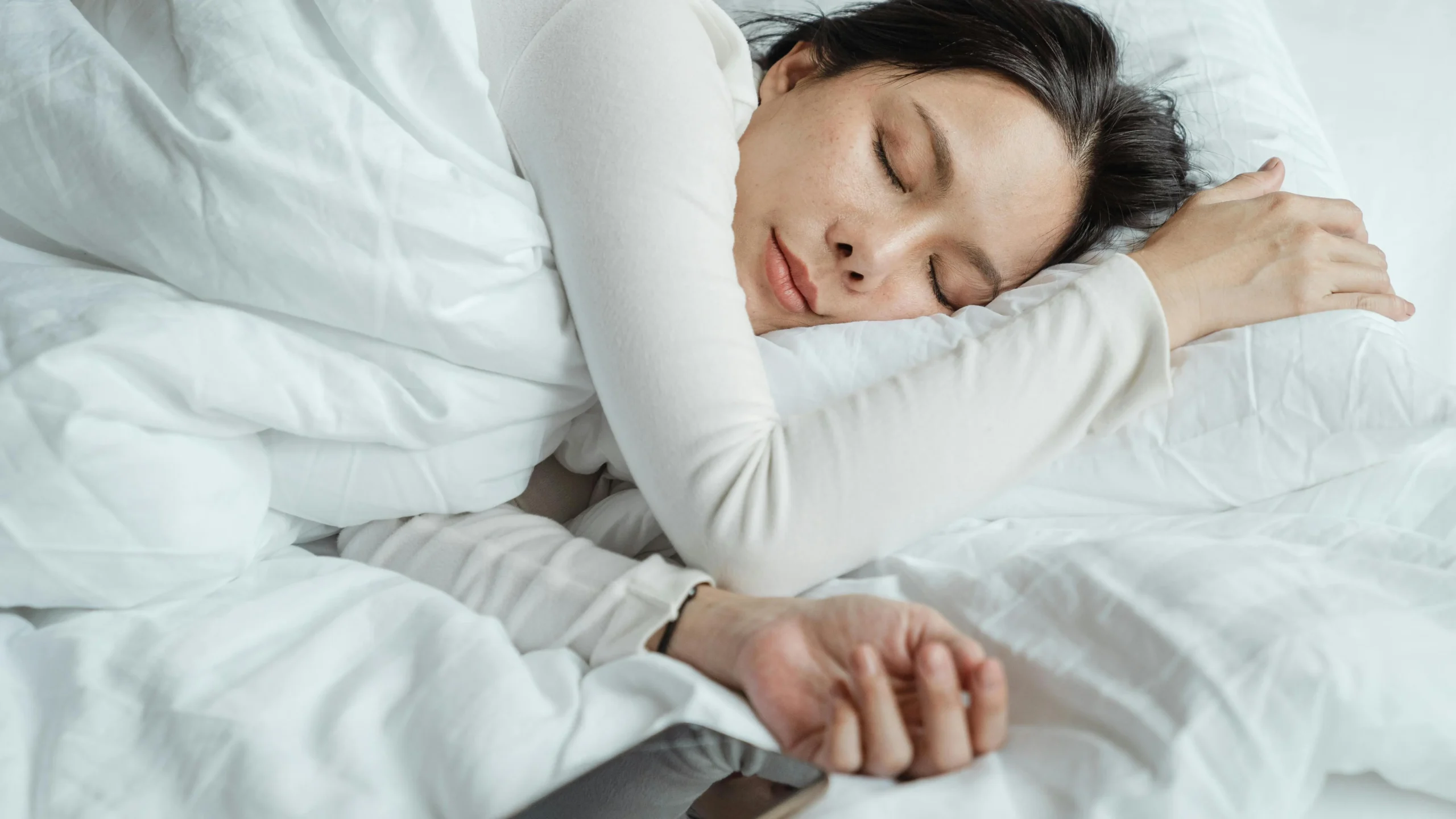 Asian woman sleeping comfortably in bed, addressing menopause vaginal itching.