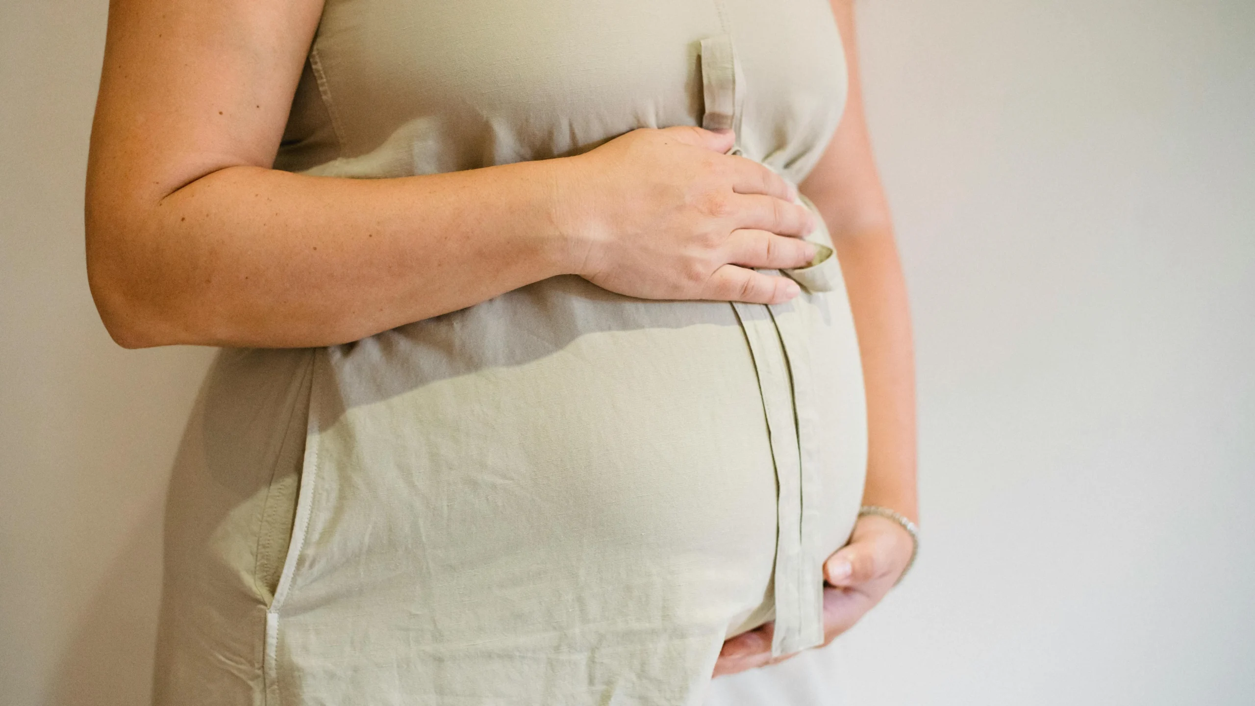 Woman holding belly, illustrating perimenopause bloating.