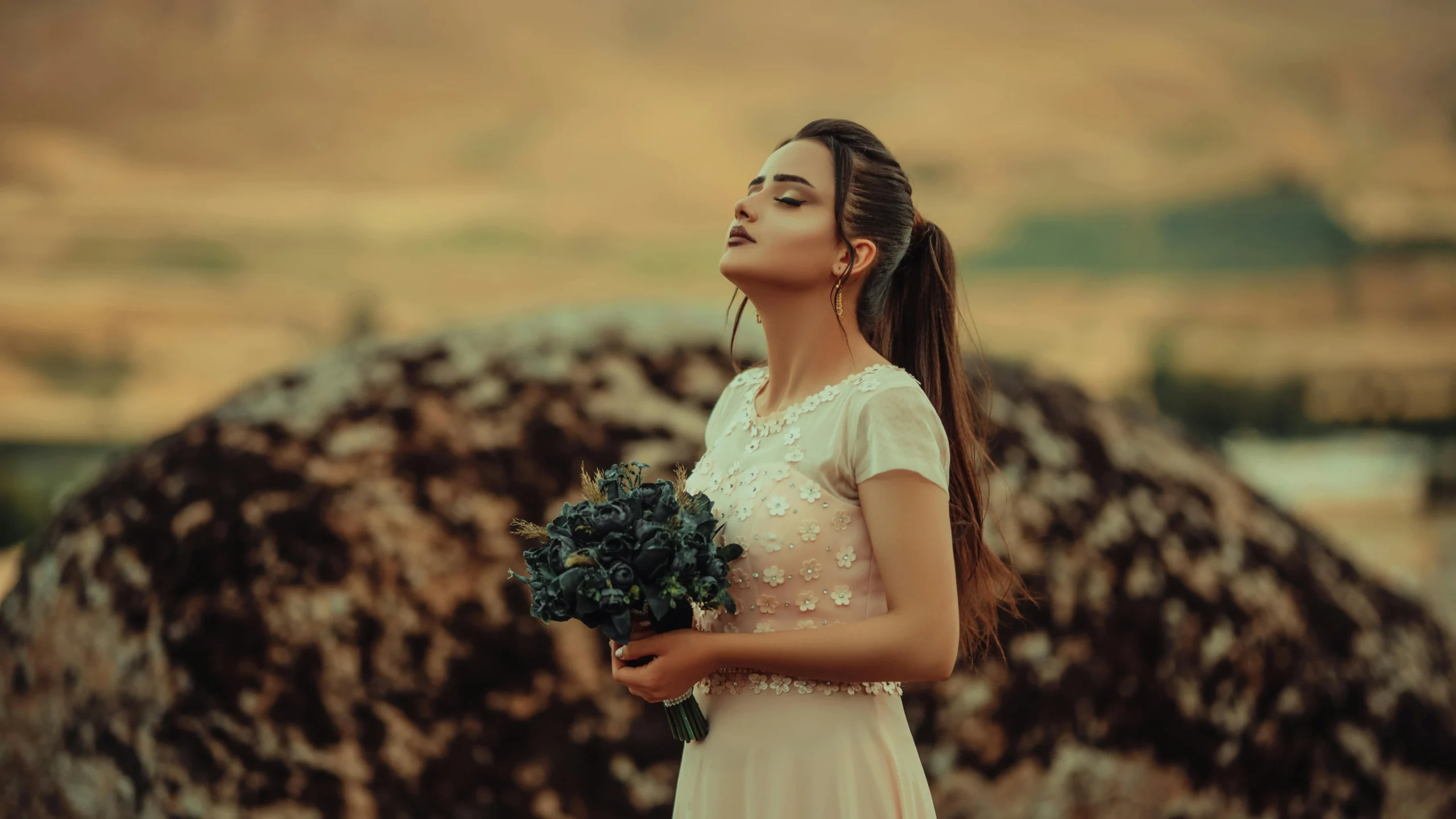 Woman experiencing vaginal itching and menopause holding flowers in a desert.