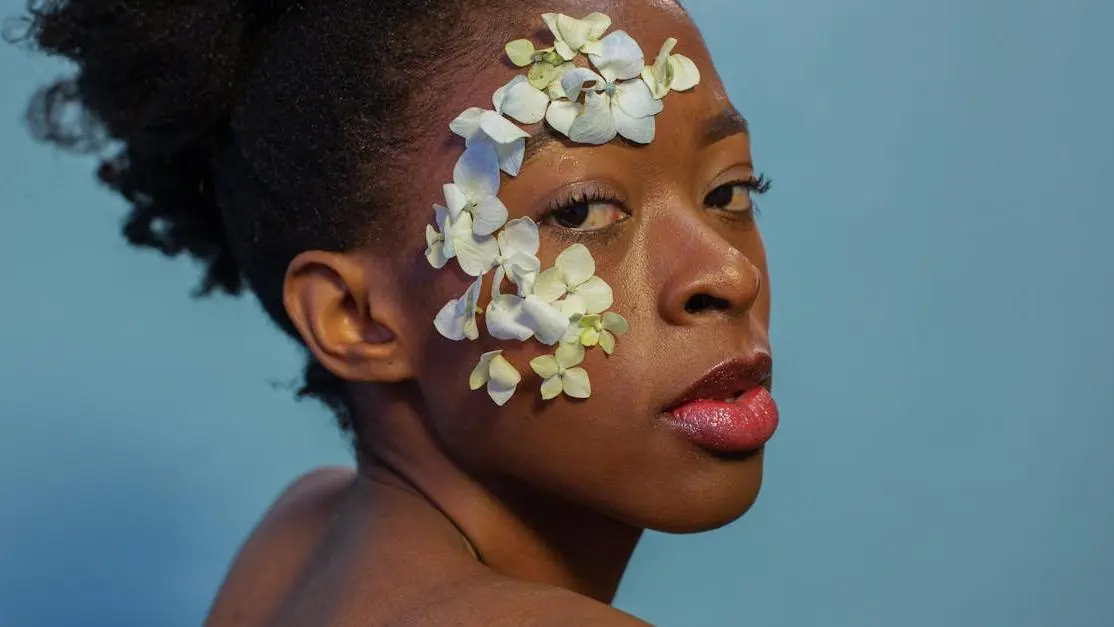 Confident black woman with flower petals, representing question "can other people smell my bv"