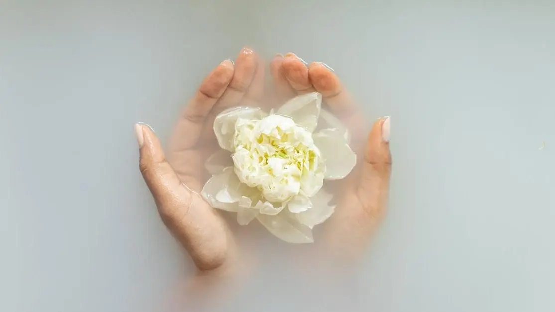 Woman holding a flower, wondering if people can smell her discharge