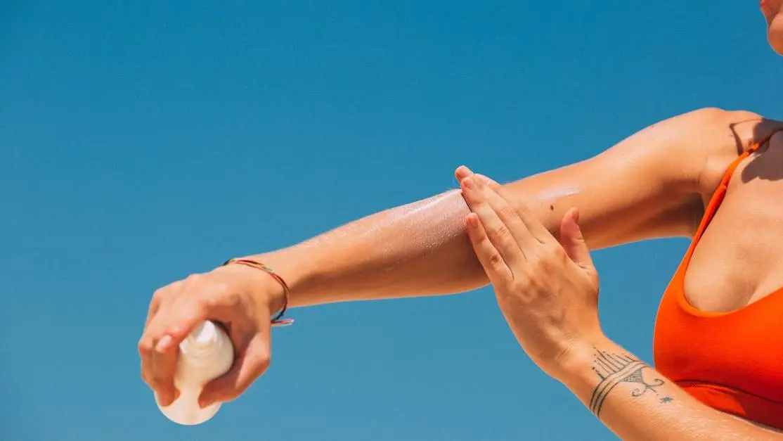 Woman applying sunscreen to avoid chafing in the groin area.