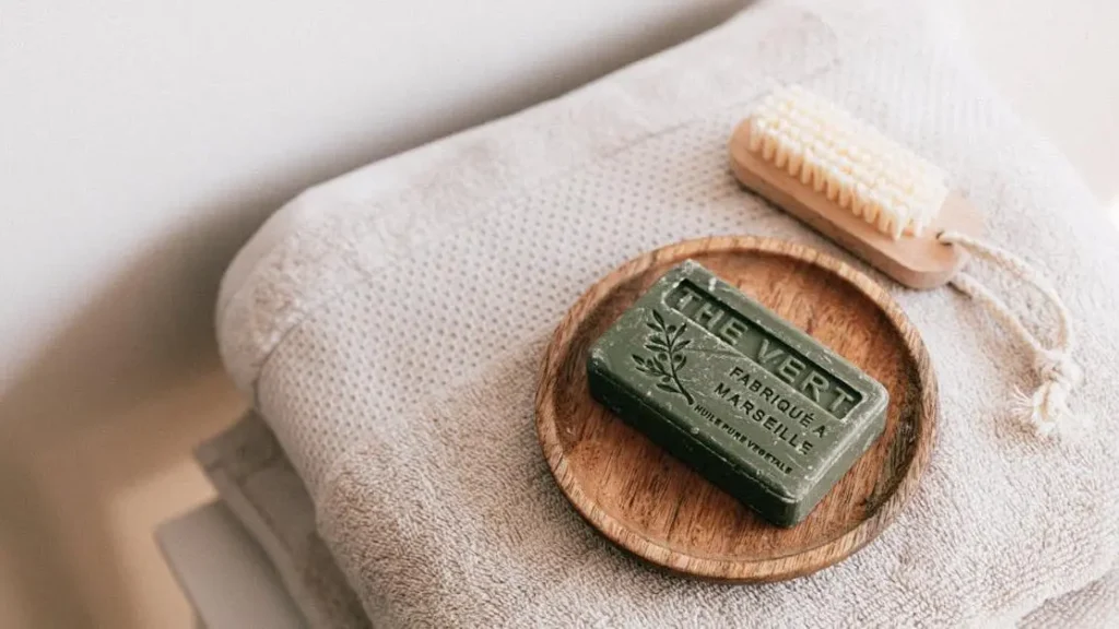 Natural soap and brush on folded towels, discussing if soap causes yeast infections