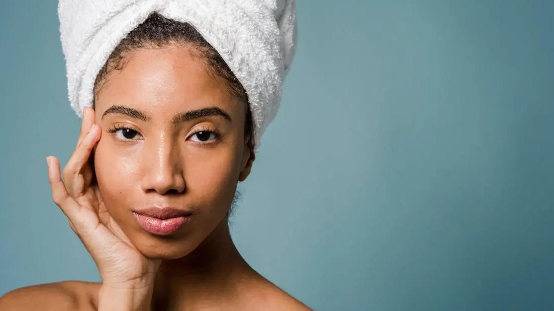 Young black woman touching her face after spa procedures, representing heat rash under breast prevention