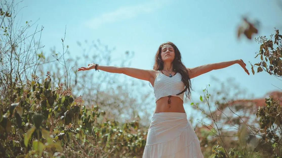 Woman with arms spread wide, conveying a fresh feeling related to how to stop vaginal smell