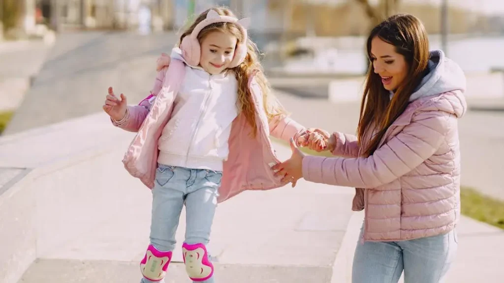 Mother helping little girl on roller skates, showing how to keep thighs from chafing