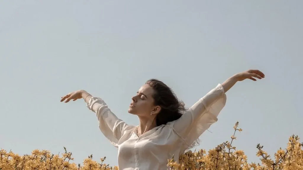 Woman in a flower field experiencing menopause itching.