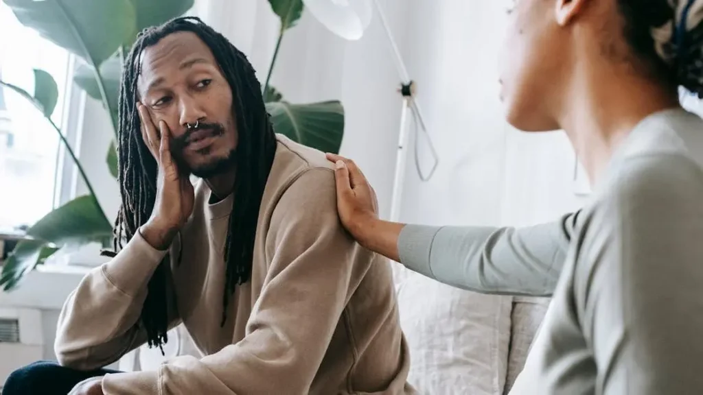 Ethnic psychologist comforting black patient with underboob rash