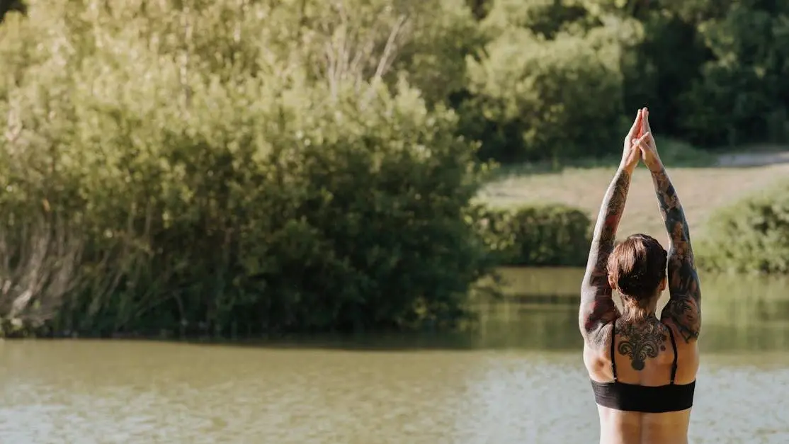 Woman in sportswear practicing yoga by lake, discussing antidepressants for hot flashes