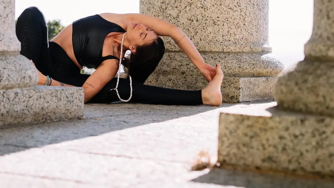 Woman stretching in black tank top and leggings, addressing belly fat during menopause.