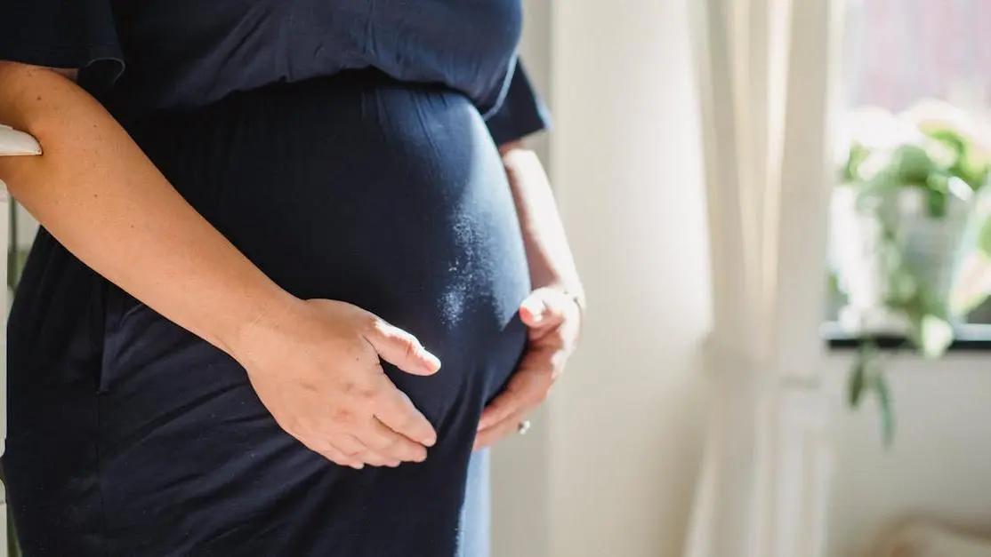 Expectant mother stroking belly, representing BV and Yeast Infections During Pregnancy