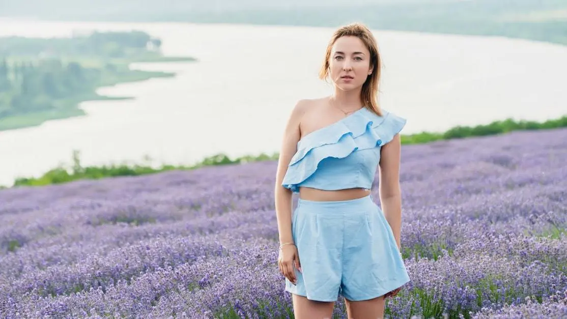 Woman in blue dress standing in lavender field, illustrating changes in menstrual cycle