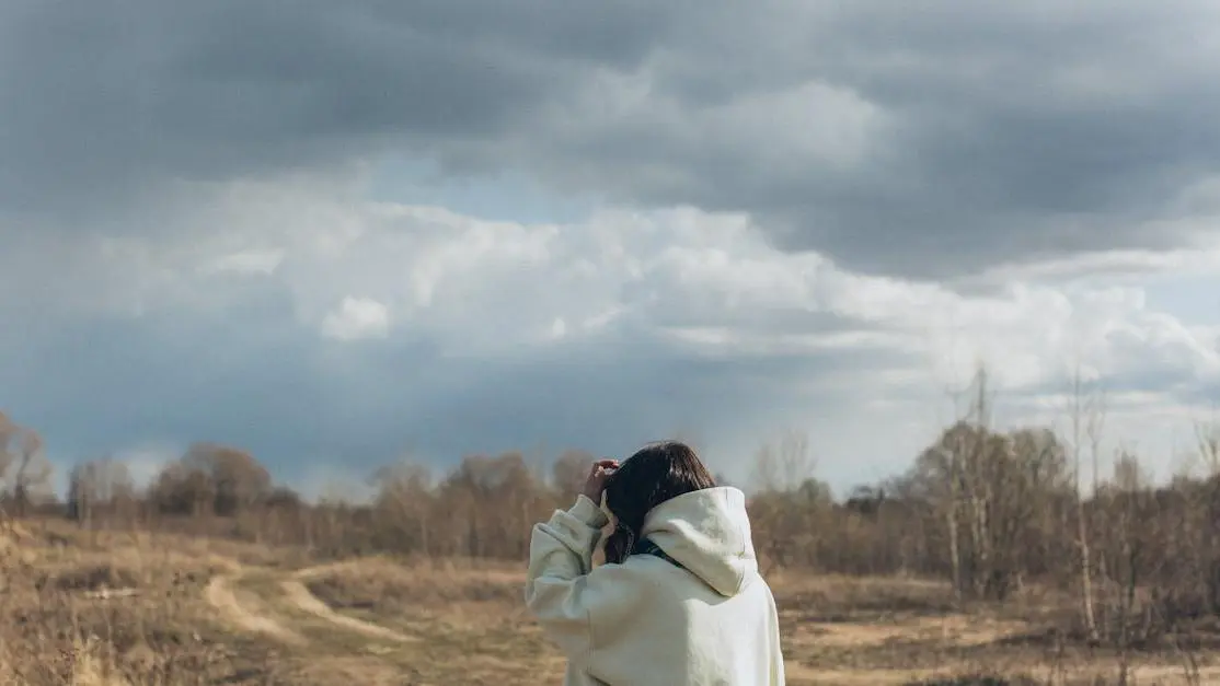 Woman standing in an autumn field reflecting on early menopause