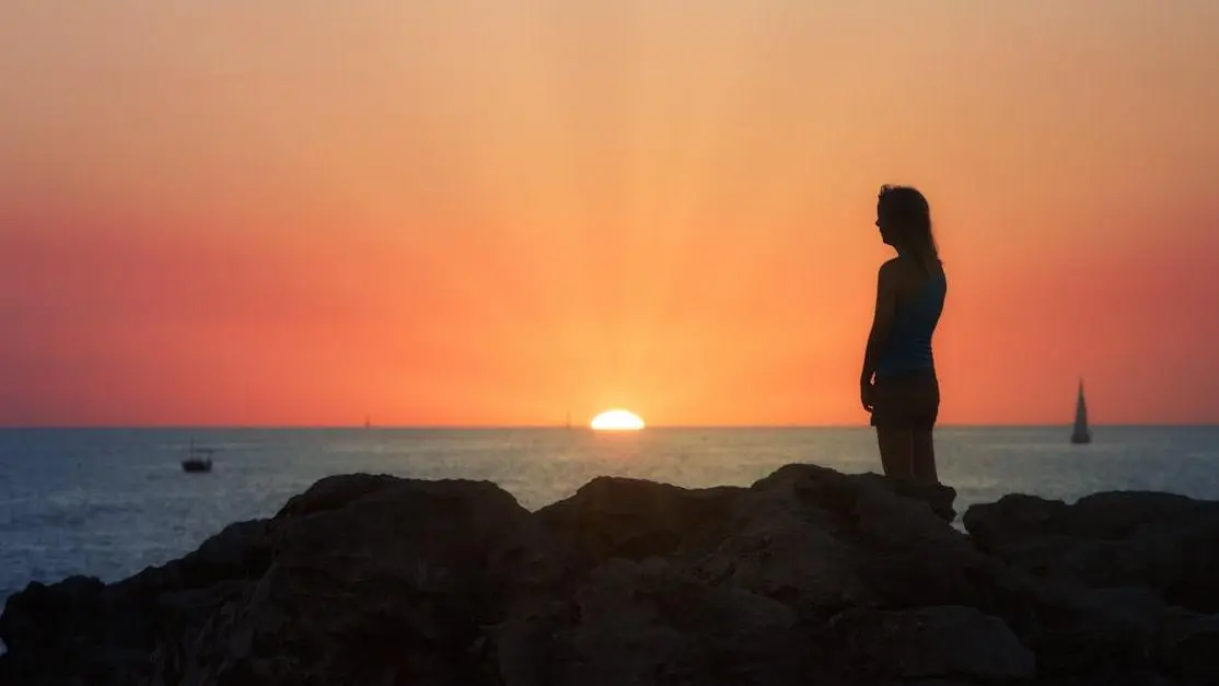 Woman by the sea at sunset, contemplating Estrogen Therapy for Hot Flashes