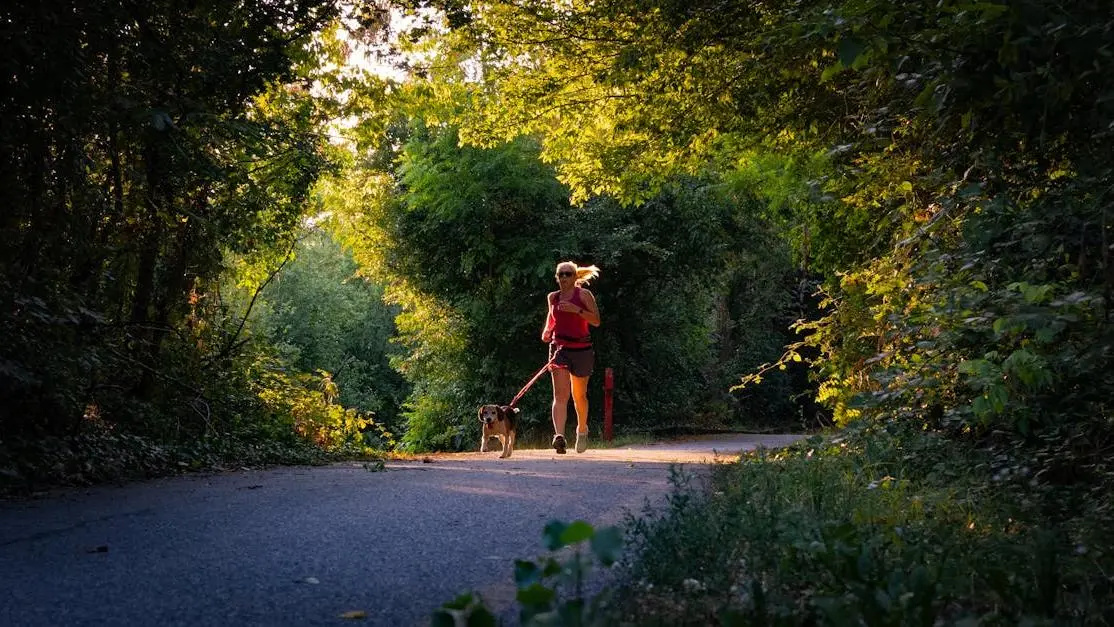 Woman walking her dog in the woods, promoting exercise during menopause