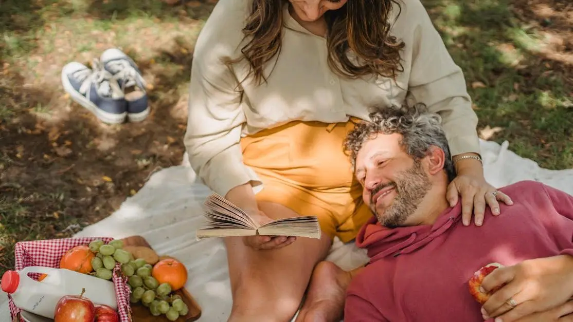 Happy couple reading about feminine odor during pregnancy in nature