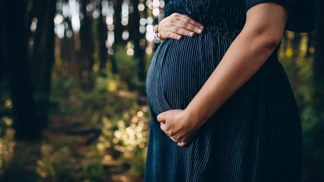 Pregnant woman in forest, experiencing feminine odor during pregnancy