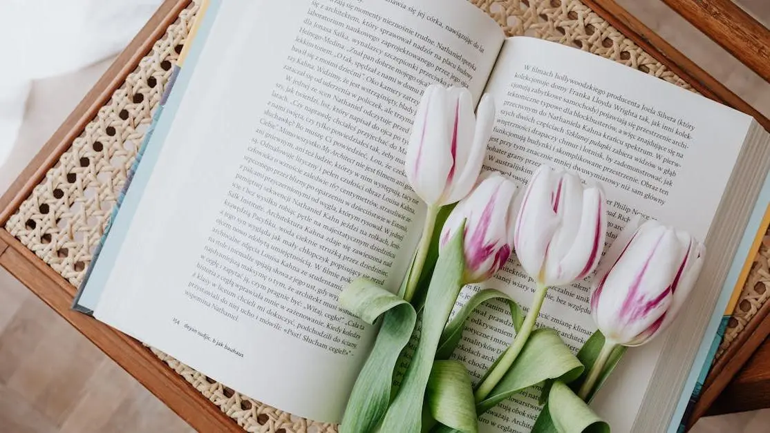 Fresh flowers on open book atop vintage wicker table