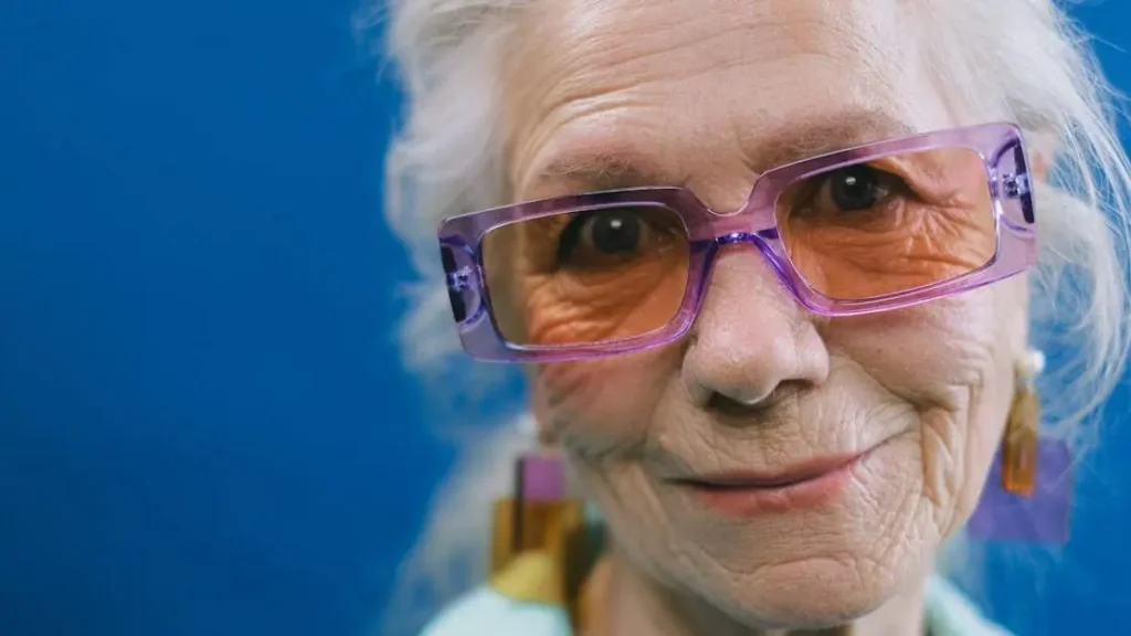 Senior woman with gray hair smiling, reflecting on hair thinning and menopause.