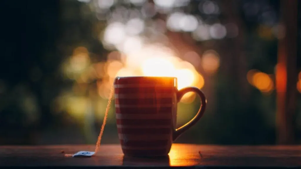 Herbal tea for night sweats on a wooden windowsill at sundown