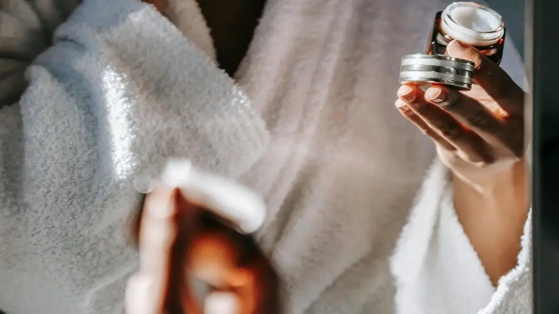 Woman applying homemade cream for recurring BV in front of mirror