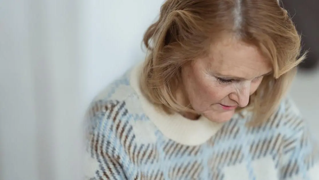 Smiling middle-aged woman with blond hair, highlighting contentment and confidence related to hormonal and skin health during menopause.