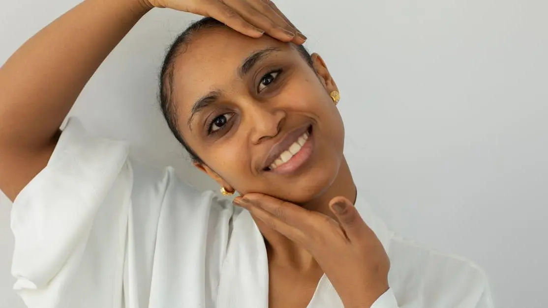 Smiling Indian woman with clear skin, illustrating the benefits of Hormone Replacement Therapy (HRT) and skin.