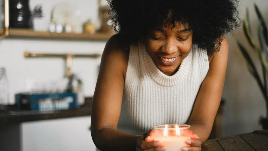 Cheerful black woman experiencing hot flashes at 4 weeks pregnant, holding a burning candle