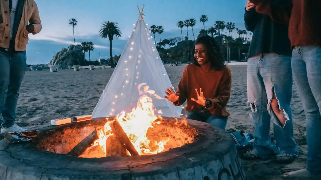 Pregnant woman experiencing hot flashes warming hands by the fire pit