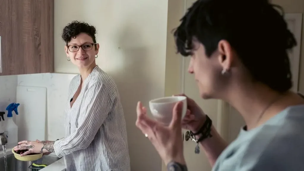 Young woman washing fruits, discussing hot flashes vitamin E benefits with friend over coffee