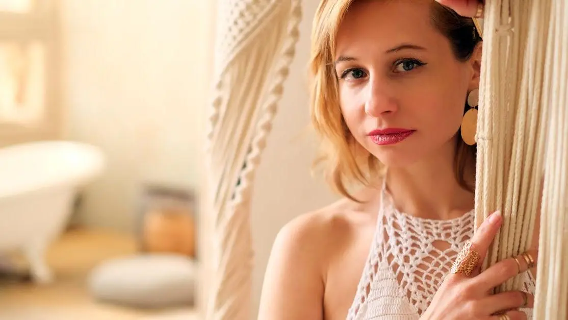 Young woman in white underwear near beige curtains, representing "How to choose the Right Underwear to Prevent BV"