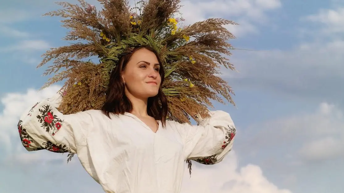 Woman in white long sleeve shirt standing beside green tree to illustrate How To Manage Peri Menopause.