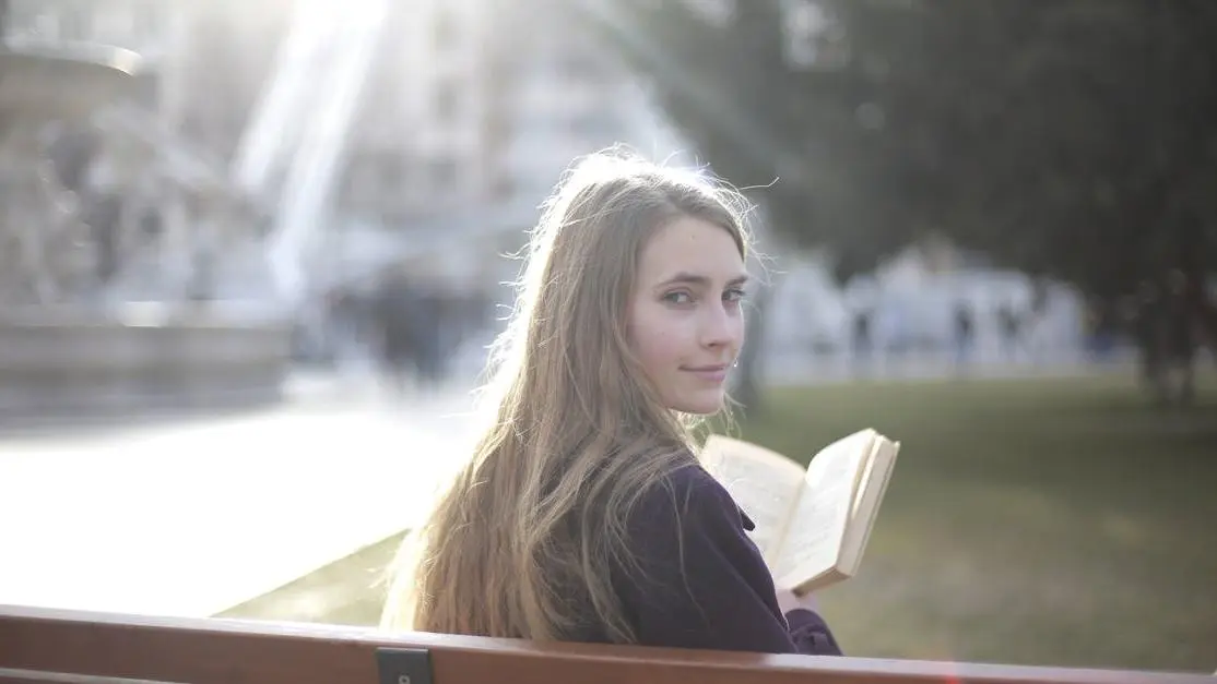 Woman in casual jacket relaxing on park bench, illustrating "How To Prevent Hot Flashes"