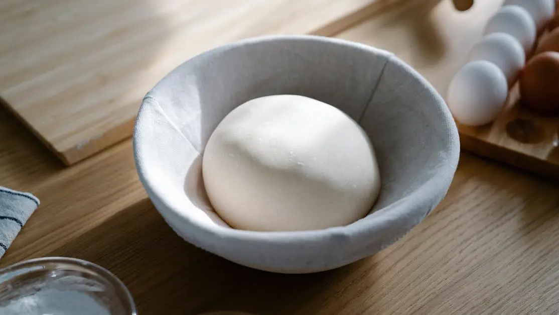 Dough rising in a bowl, illustrating how yeast infections develop.