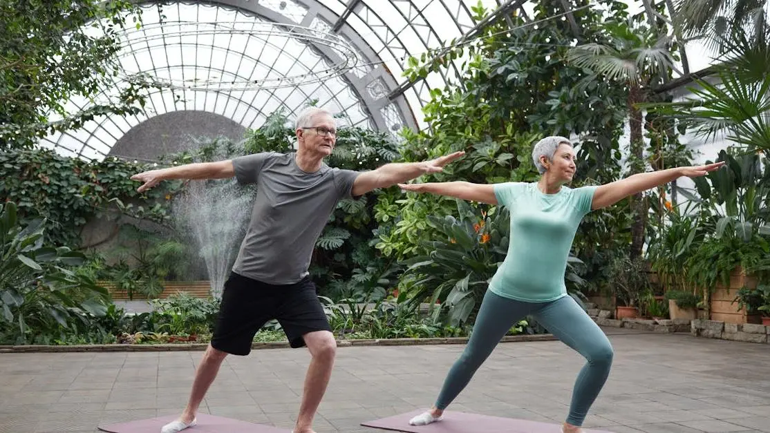 Couple practicing yoga to promote bone health during menopause with HRT benefits.