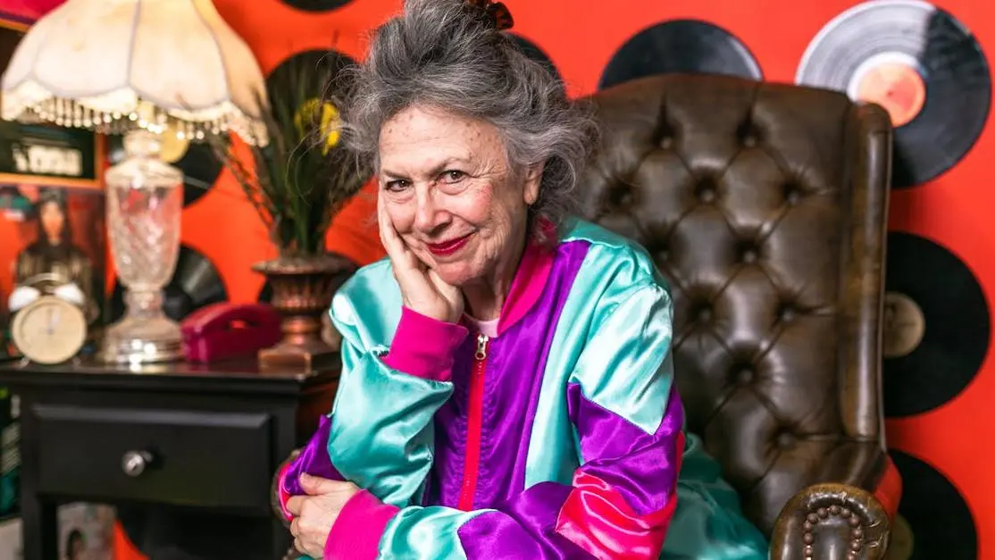 Elderly woman smiling in chair, highlighting HRT and Mental Health during menopause