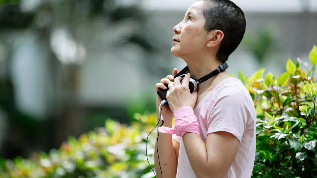 Woman in headphones near green plants, symbolizing HRT and Sexual Health during menopause