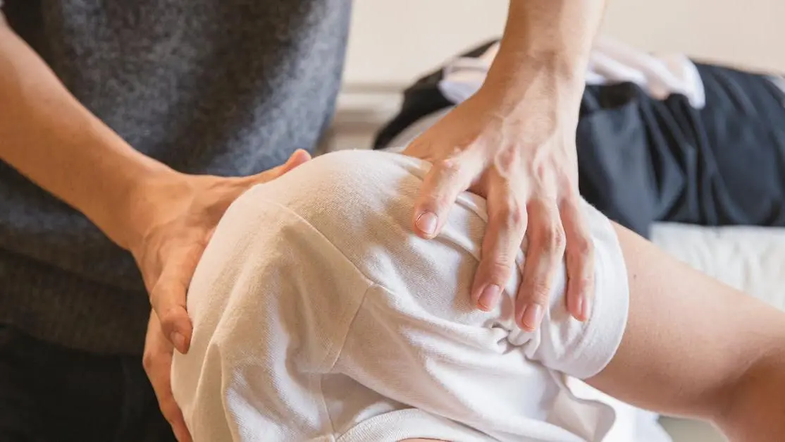 Medical specialist massaging shoulders of client to alleviate joint pain and stiffness