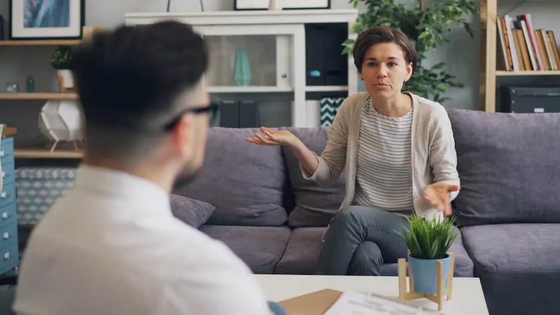 Woman discussing managing menopause symptoms at work with male colleague