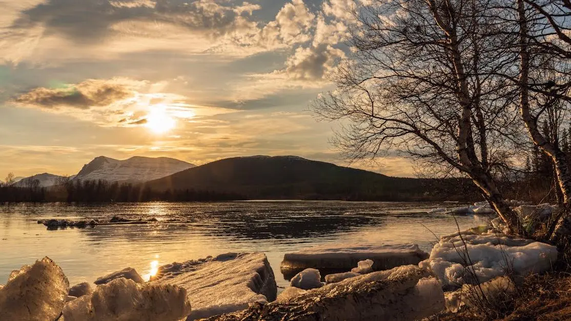 Sunset over an icy lake surrounded by trees, illustrating tranquility for meditation menopause.