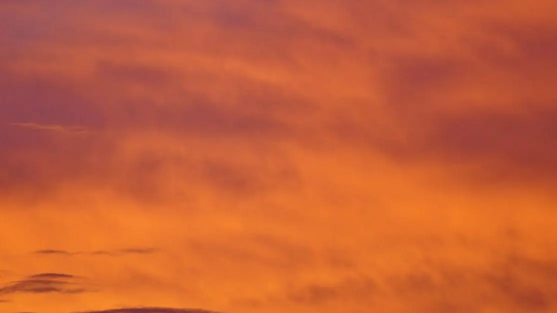 Sunset over a city skyline with an orange sky