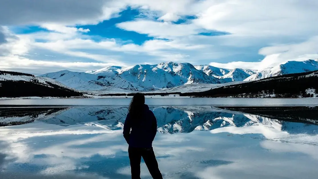 Woman facing snow-capped mountain, symbolizing the mental health journey during menopause.