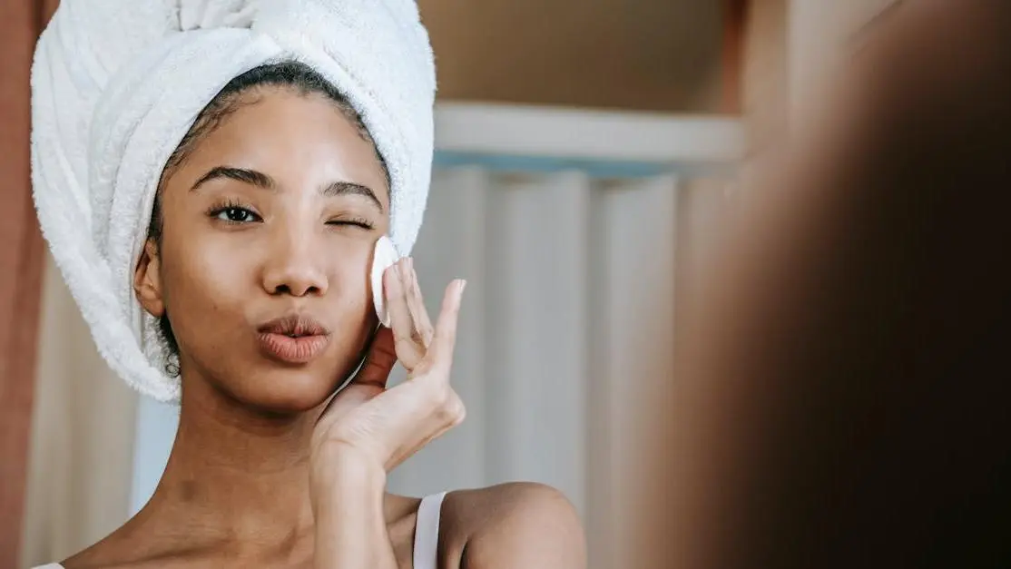 Woman winking while using cotton pad during skincare routine, highlighting Menopause and Skin Dryness.