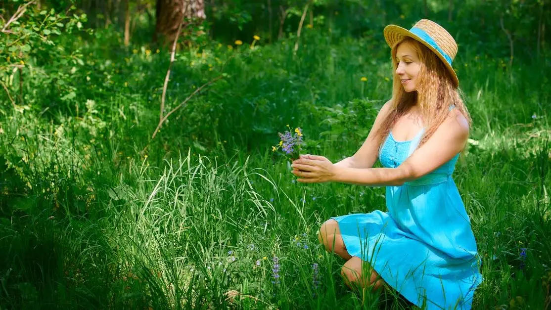 Woman in blue dress kneeling in grass, debunking Myth: Menopause Always Causes Severe Symptoms