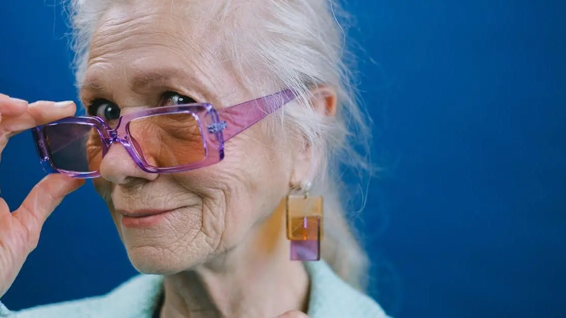 Smiling elderly woman in purple glasses debunking "Myth: Menopause Causes Depression"