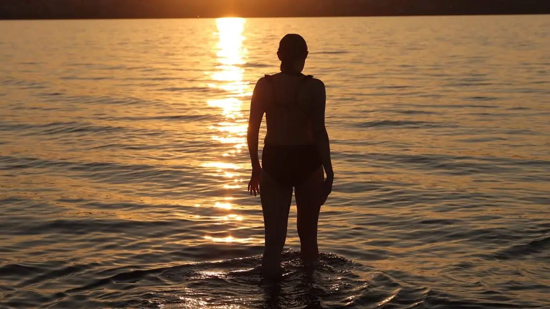 Woman in water at sunset, debunking "Myth: Menopause is the End of Youth"