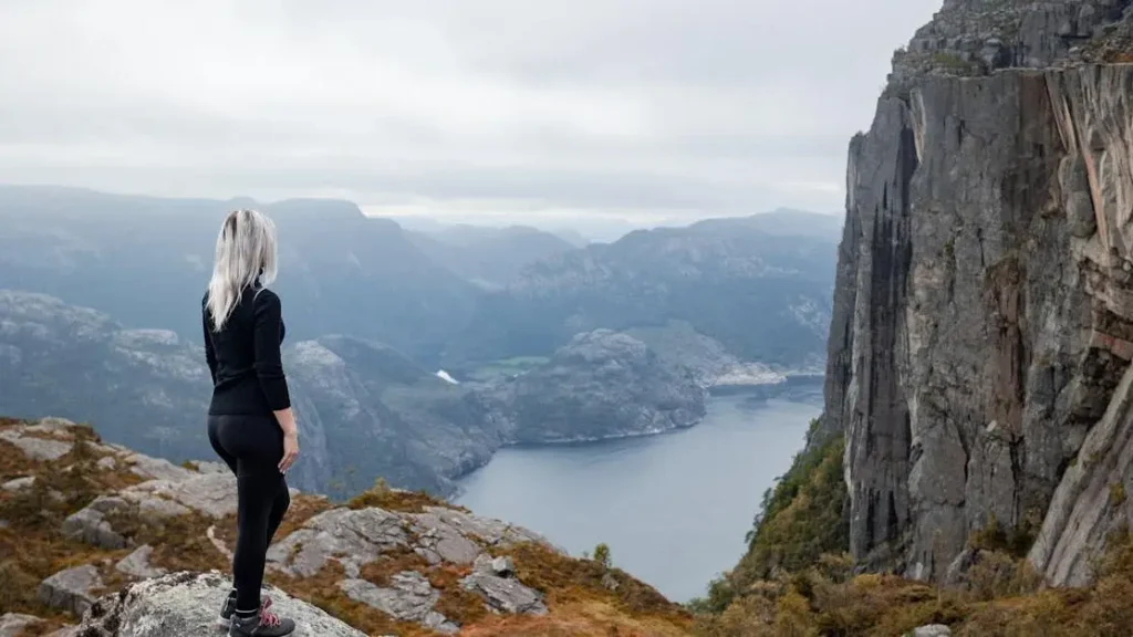 Girl hiking on cliff in Norway, exploring the myth that menopause only affects physical health