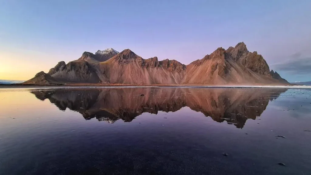 Rocky island with mountains, clear blue lake, and melting ice at twilight; related to perimenopause mood swings treatment.